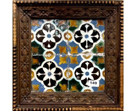 Four 18th century Moorish ceramic tiles in a carved wooden frame, 38 x 38cm.