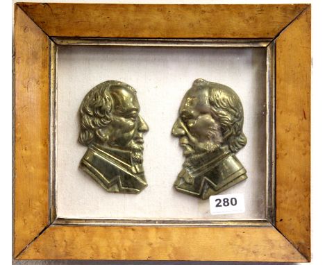 A 19th century framed pair of brass portrait busts of Disraeli and Gladstone, 32 x 28cm.