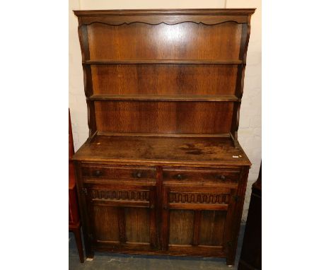 An oak Welsh dresser, with carved panelled doors, and rear plate display shelf, 190cm high, 122cm wide.