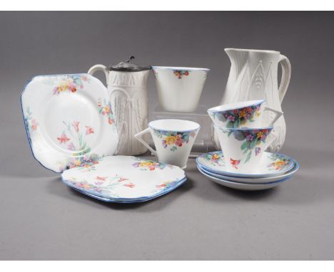 An Art Deco bone china floral decorated part tea service for three, and two 19th century relief decorated jugs 