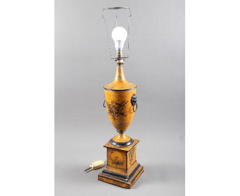 A toleware urn-shaped table lamp with lion mask ring handles and basket of flower decoration, on a square pedestal stepped ba