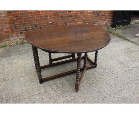 A 19th century oak drop leaf dining table, on bobbin turned and stretchered supports, 50" wide x 61" deep x 30" high 