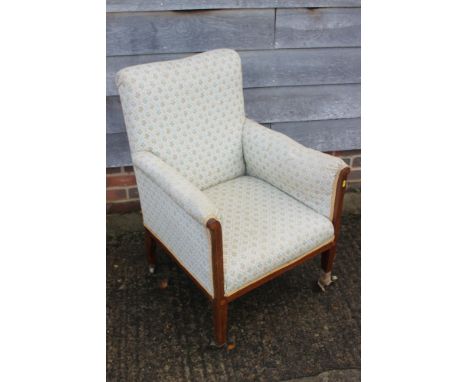 An Edwardian mahogany and inlaid showframe armchair, upholstered in a floral tapestry, on square taper supports 