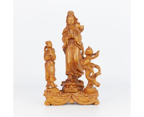 A Chinese Republic period boxwood carving depicting a praying robed Guanyin figure atop a dragon's head with an additional fi