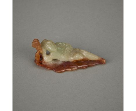 Chinese carved jade depicting a figure reclining along the length of a leaf. The body is of a pale green coloration and the f