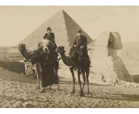 Late 19th century albumen photograph print depicting two figures atop camels posing in front of the Great Sphinx and the Grea