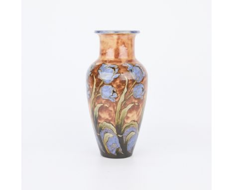 Royal Doulton, England. Lovely ceramic baluster vase depicting blue tulips on a brown mottled ground along the exterior. Stam