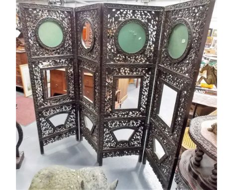 Good Chinese hardwood carved and pierced four fold screen, each panel with a circular rectangular and fan shaped aperture wit