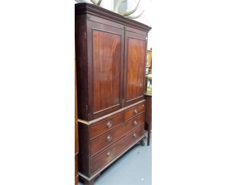 George III mahogany linen press, the moulded cornice over a pair of cupboard doors enclosing one slide, the base with two sho