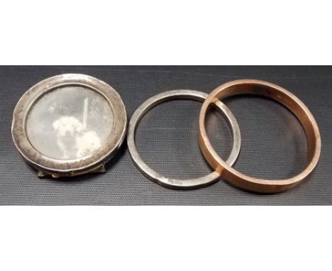 Silver hollow bangle; together with a gold plated hollow bangle and a small circular silver mounted photograph frame (3).