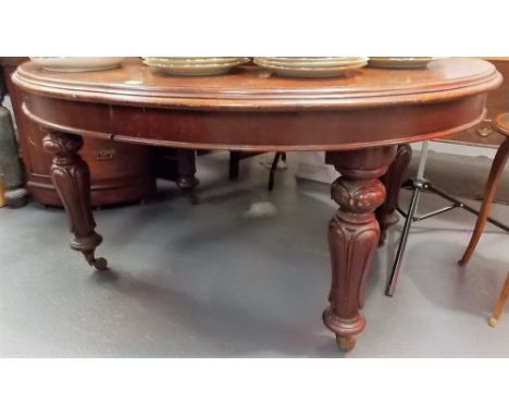 Victorian mahogany oval extending dining table upon carved baluster legs with brass caps and ceramic castors including two ex