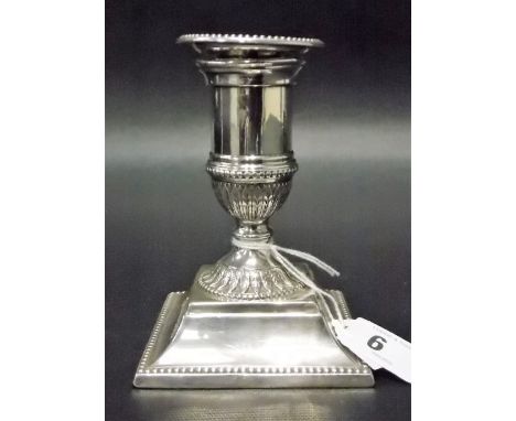 Edwardian silver weighted squat candlestick with beaded rims and acanthus stiff leaf embossed collars, height 4.5in, London p