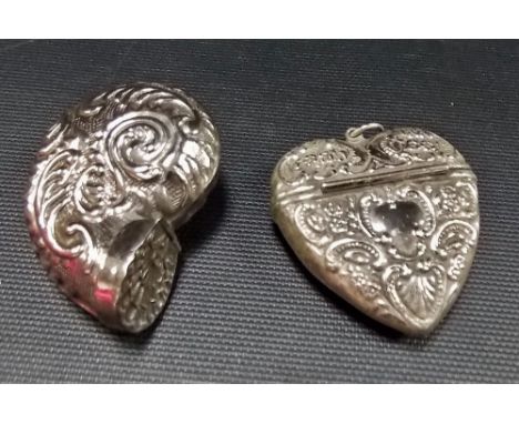 White metal snuff box in the form of a shell, foliate embossed; together with a white metal heart shaped embossed locket (2)