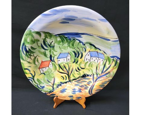 CONTEMPORARY CERAMIC CHARGER BY SUZANNE KATHUDA with a rural scene depicting houses with colourful roofs in trees with ocean 