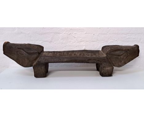 FOLK ART HARDWOOD PIG BENCH / STOOLwith engraved pig heads to each side, atop two legs122cm long, 27cm high and 29cm deep