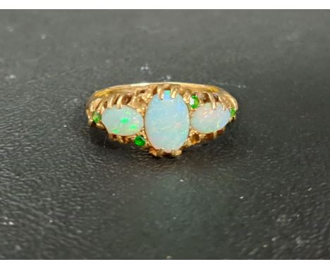 OPAL AND DEMANTOID GARNET EIGHTEEN CARAT GOLD RINGthe three opal stones with small demantoids to the surround, on eighteen ca