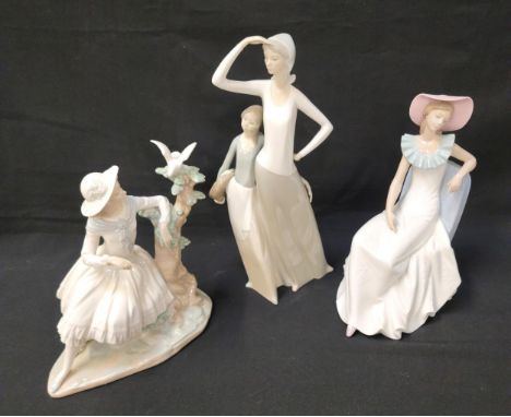 THREE LARGE NAO FIGURINESconsisting of seated lady watching Dove in a tree, 24cm high; seated lady in pink hat, 26cm high; an