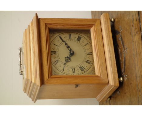 Light oak bracket clock, stepped case, square silvered dial, Quartz movement, with carry handle and turned brass feet, H27cm 