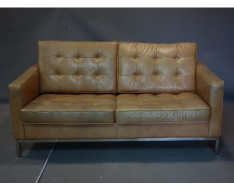 A Florence Knoll style tan leather sofa, raised on chrome base 