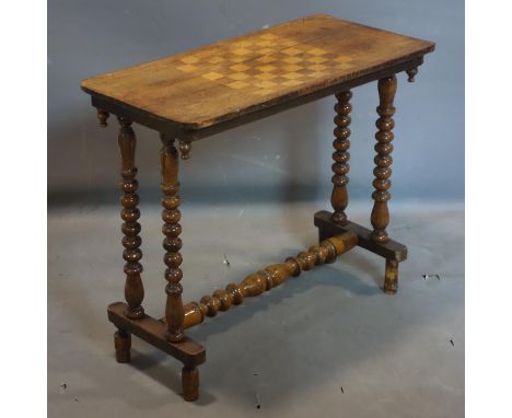 A Victorian walnut games table, raised on bobbin supports, H.67 W.76 D.38cm 