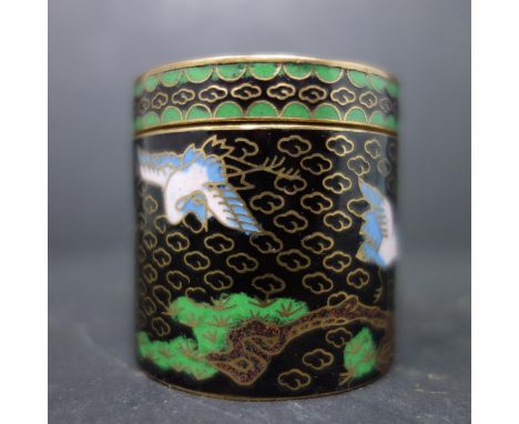 A small Chinese cloisonne enamel box, decorated in pink, blue and green with cranes amongst trees on a black ground, H.4.6cm 