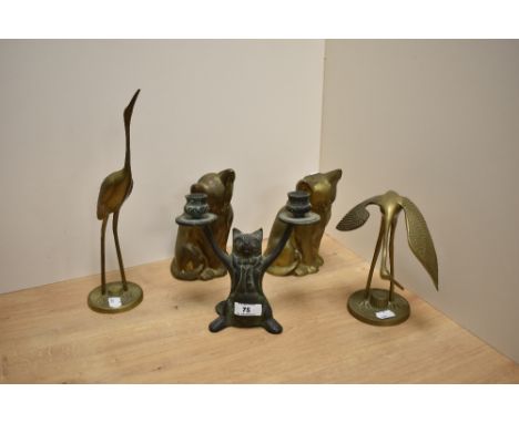 A decorative cast-brass anthropomorphic cat two branch candlestick, formed as a tuxedo wearing cat with arms held aloft, 18cm
