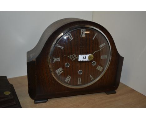 A 1940's oak cased Westminster Chime mantel clock, of arched form with Roman hours to the chapter ring, enclosing three windi
