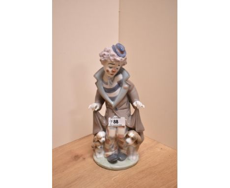 A Lladro porcelain clown group 'Suprise' number 5091, modelled as a forlorn clown revealing a dog and two puppies from under 