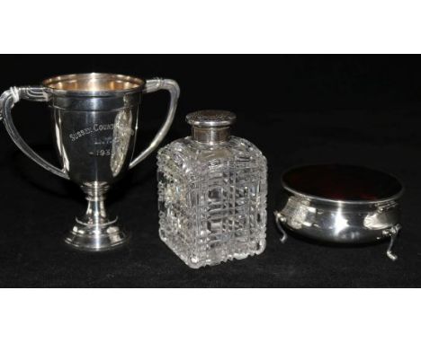 An Edwardian silver and tortoiseshell trinket box, a silver top bottle and a small silver trophy cup.