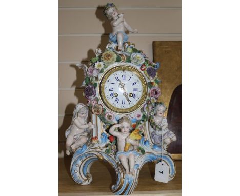 A late 19th century Thuringian porcelain mantel clock, encrusted with flowers, mounted with cherubs (some faults)