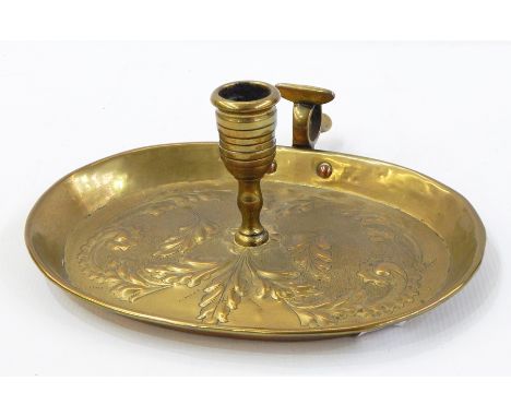 Georgian brass chamber candlestick, the oval tray repousse with scrolling leaves, 24cm wide 