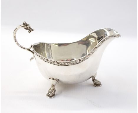 George V silver sauceboat with Celtic reed pattern border, raised on short cabriole legs with dragon feet, Birmingham 1920, 6