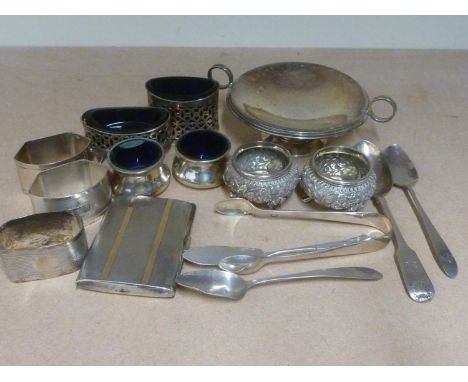 Silver two handled tazza, three napkin rings, three spoons, tongs and six condiments and a cigarette case with gold gold inla