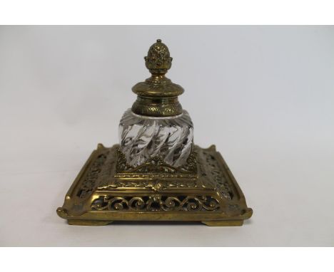 19th century large glass inkwell of spiral reeded square form, the brass cover with pineapple finial, on square foliate pierc