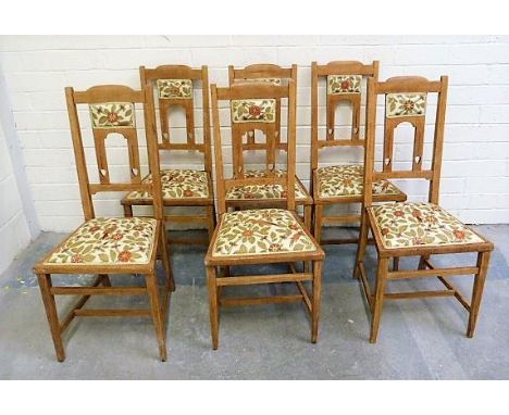 Set of six light oak arts and crafts style dining chairs in the Liberty style with central rose motif, upholstered seats on s