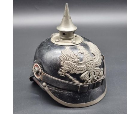 A WWI Prussian infantry pickelhaube, black leather with grey metal fittings and removable bayonet fitting spike.