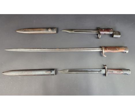 A British No7 Mk1 Land Service bayonet and scabbard; together with two other bayonets. (3)
