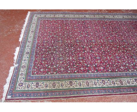  A Middle Eastern carpet   with a field of flowers on a red ground.300cm x 200cm. 