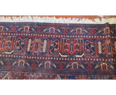  A Kashan Carpet  , with a central diamond medallion with stylised flowers on a red ground and blue borders.420cm x 310cm. 