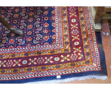  A Middle Eastern style carpet   with a geometric central panel on a blue ground.320cm x 200cm 