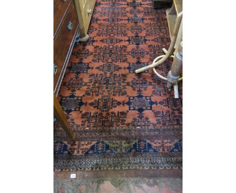  An Afghan carpet   with an all over geometric pattern on a  rusty coloured ground.350cm x 260cm 