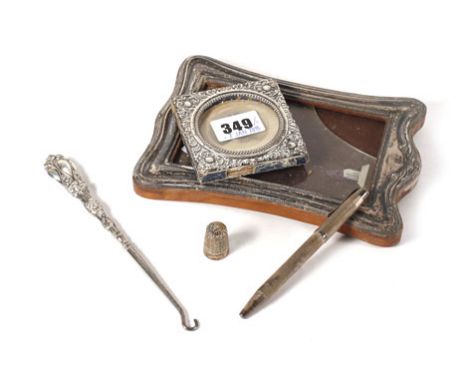 A silver photograph frame of rectangular form, aperture 12.5 x 7.5 cm, another of square form, a button hook, a thimble and a