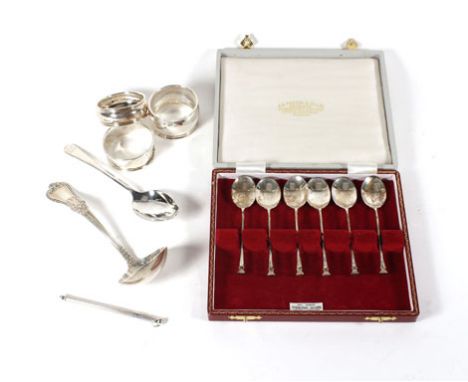 A small parcel of silver items including a set of six seal end teaspoons, three napkin rings, a teaspoons, a sauce ladle and 