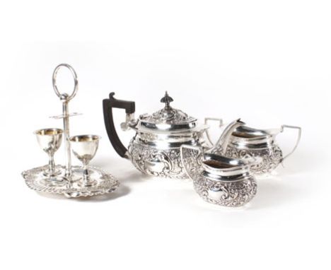 A silver plated three piece repousse decorated tea service and a plated duet egg cup stand Stand lacking spoons