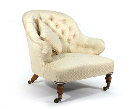 A Victorian fully upholstered fireside armchair with button backed on turned legs Re-upholstered, structurally sound