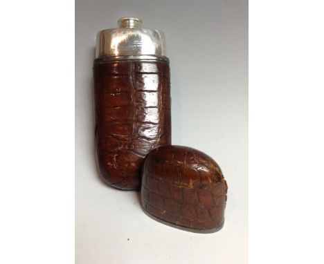 An early 20th century crocodile skin gentleman's hip flask, push-fitting cover enclosing a screw cap, silver plated mounts, 1