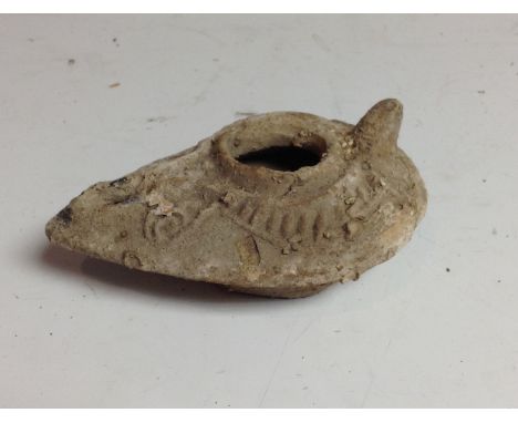 Antiquities - a medieval Persian pottery oil lamp, moulded in low relief with geometric motifs, raised thumbpiece, 9.5cm long