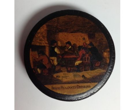 A 19th century Stovwasser-type papier-mâché circular snuff box, the push on cover applied with a tavern scene of Irish Peasan