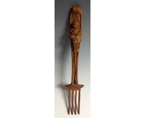 A Black Forest fork, the handle carved with a young girl stirring a pan, 26cm long, c.1900