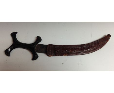 A Sudanese Hadendoa dagger, 22cm curved blade, curved X-shaped hardwood handle, red hide scabbard, 31cm long overall, early 2